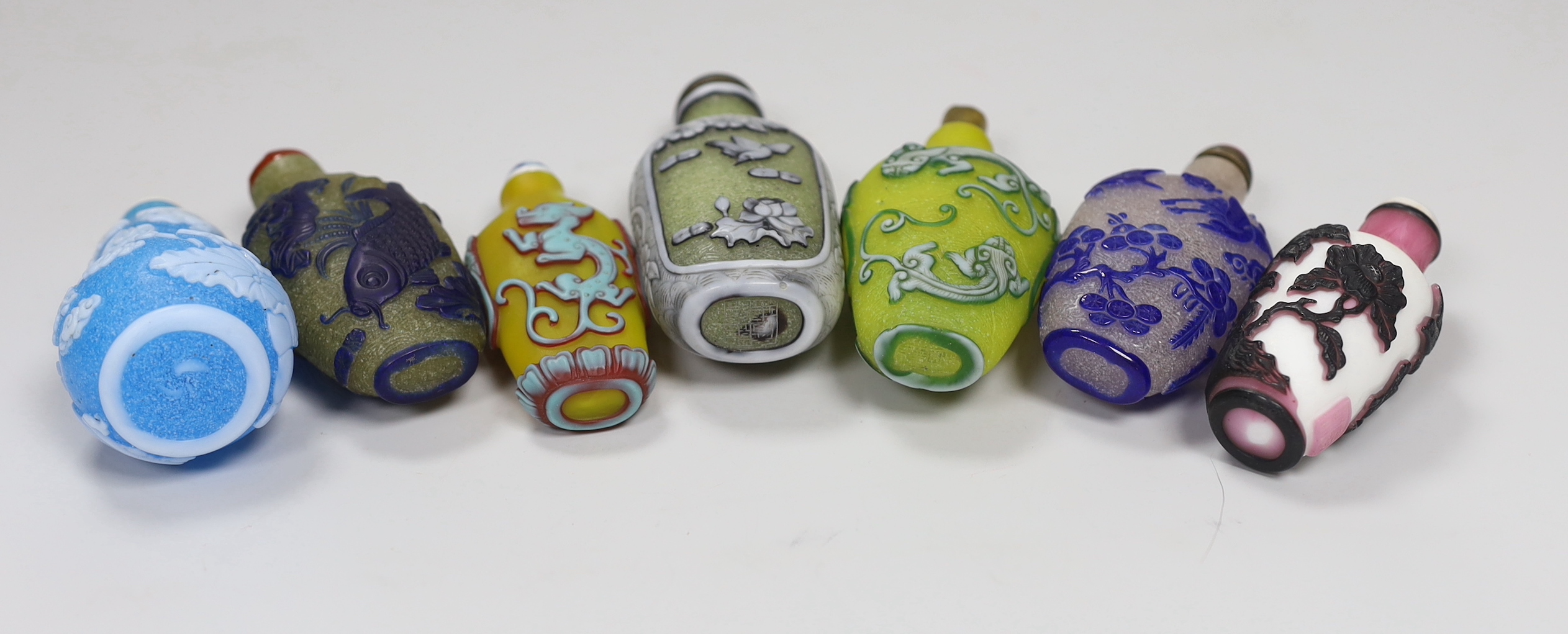 Seven Chinese overlaid glass snuff bottles, tallest 10cm high